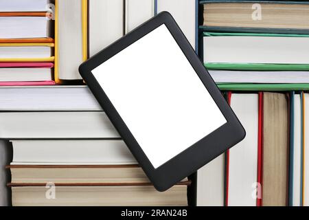 Portable e-book reader on different hardcover books, top view Stock Photo