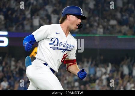 Los Angeles Dodgers' Jonny Deluca, center, is congratulated by Miguel  Rojas, right, after scoring on a balk as Houston Astros catcher Yainer Diaz  kneels at the plate during the eighth inning of