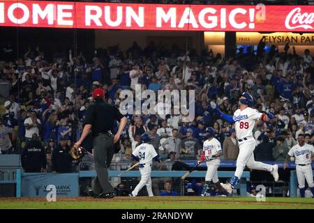 Los Angeles Dodgers' Jonny Deluca, center, is congratulated by Miguel  Rojas, right, after scoring on a balk as Houston Astros catcher Yainer Diaz  kneels at the plate during the eighth inning of