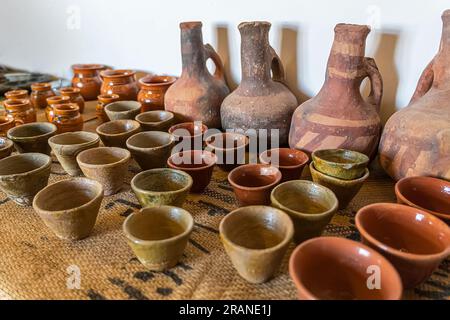 small coffee mugs and a jug on the table. Ceramics, a ceramic product made with their own hands, made on a potter's wheel, jug, mug, clay, ornament. Stock Photo