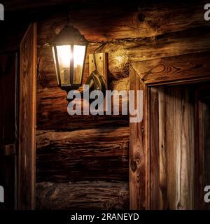 Lamp on the wall of an old wooden log house. Stock Photo