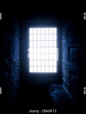 Rays of moonlight break through the narrow window of the old castle. Stock Photo