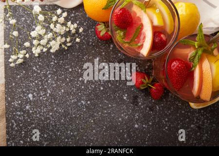 Top view of refreshing aesthetic vitaminized summer detox water, cocktails with citrus fruits and strawberry. Low alcohol, zero proof beverages concep Stock Photo