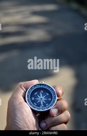 Close-up holding navigation compass outdoor blur background Stock Photo