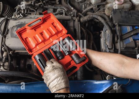 Auto mechanic chooses a tool from a car maintenance kit Stock Photo