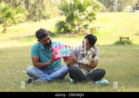 couple dreaming for the property they are buying to purchase. Happy Indian couple lying on the grass waiting happily for their property Stock Photo