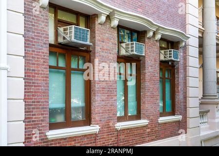 Close-up of an air conditioner window unit installed on a window of a residential building in Hong Kong Stock Photo