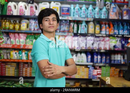 Portrait of Happy and smiling fit boy purchasing in a grocery store. Buying grocery for home in a supermarket. Stock Photo