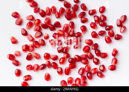 Large ripe pomegranate seeds on a white background, top view, flat lay, background of pomegranate seeds. Stock Photo