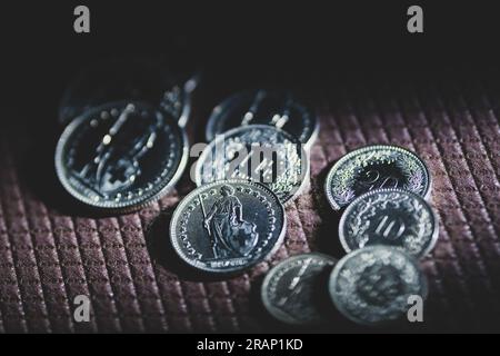 Swiss franc coins resting on a brown textured background. Stock Photo