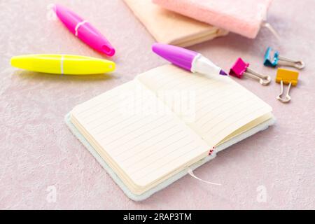 Blank open notebook, markers and binder clips on light background Stock Photo