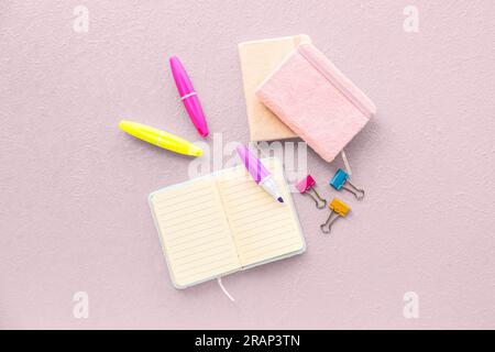 Composition with notebooks, markers and binder clips on light background Stock Photo