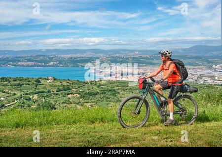nice active senior woman on a mountain bike tour at the Slovenian Mediterranen cost above harbour city of Koper, Slovenia. Europe Stock Photo