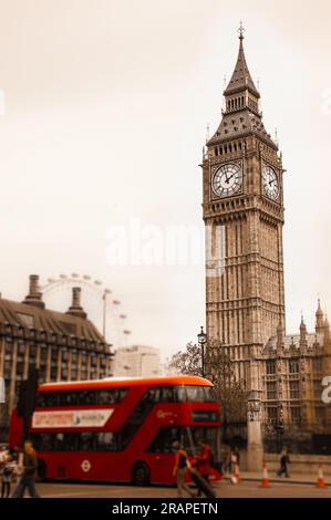 Big Ben and blurred red double decker bus, tourists and London Eye. (London, UK). Aged photo. Stock Photo