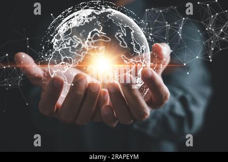 A businessman's hand holds a globe, illustrating seamless connectivity and data flow across global network Stock Photo