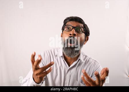 Portrait of Indian bearded man wearing shirt. Funky expressions stunned. flabbergast. startle. overwhelmed. delightful. staggering. stunned. surprised Stock Photo