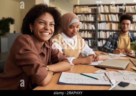 Group of students studying foreign language together at table in library Stock Photo
