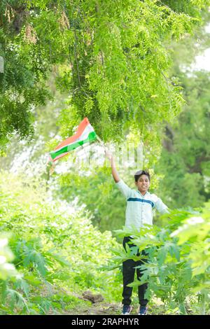 Indian boy holding national flag in farm, happy boy, national flag, poor kids Stock Photo