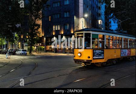 Traditional yellow tram in viale Monte Santo, Milano city center, by night, Italy Stock Photo