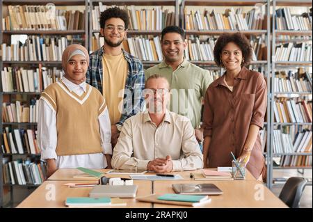 Portrait of migrant students with teacher smiling at camera while learning foreign language in class Stock Photo