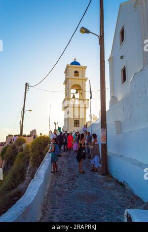 Street view of upscale Imerovigli village on a clifftop overlooking Santorini’s caldera islands.with old churches and sleek restaurants and hotels Stock Photo