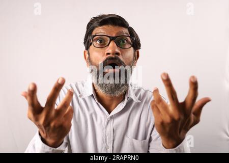Portrait of an Indian bearded man wearing shirt. Funky expressions sad and downhearted full of sorrow and regretful. Stock Photo