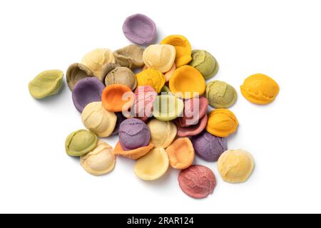 Heap of colorful Italian raw Orecchiette Arcobaleno pasta isolated on white background close up Stock Photo