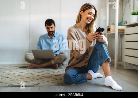 Freelancing couple working together at digital devices in home office. Social media people concept. Stock Photo