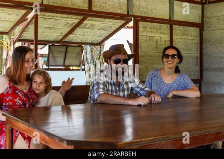 Family members father, mother and two daughters sit in alcove in park Stock Photo