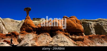 People in silhouette at Toadstool hoodoos in the Southwest with red sandstone and blue sky in wilderness Stock Photo