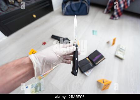 Crime scene investigation, picking up the tossed syringe and putting it to the plastic bag Stock Photo