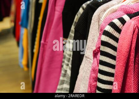 Stylish colorful clothes on hangers in the store Stock Photo