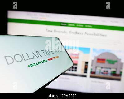 Smartphone with logo of American discount retail company Dollar Tree Inc. on screen in front of website. Focus on center of phone display. Stock Photo