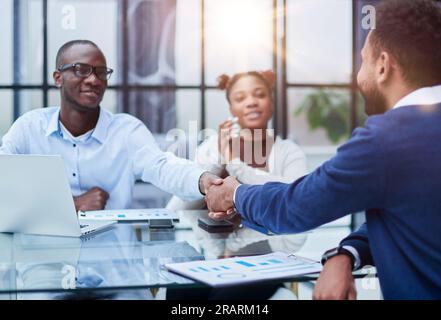 Overjoyed multiethnic businessmen shake hands greeting getting acquainted in office Stock Photo