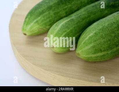 Fresh green and healthy cucumbers on wooden board Stock Photo