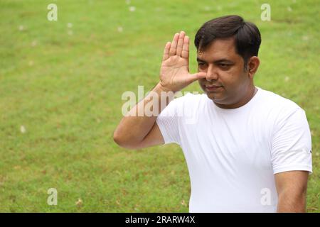 Obese man exercising and doing Yoga poses in green serene environment early morning in park to maintain healthy lifestyle. International yoga day. Stock Photo