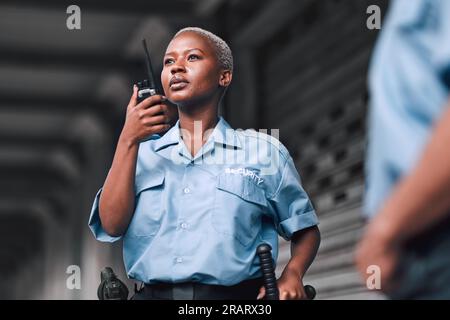 Police, communication and black woman law enforcement worker talking on walkie talkie or radio for emergency. Security, legal and officer or employee Stock Photo