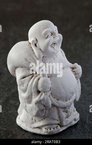 A carved miniature of the god, Buddha, walking and laughing Stock Photo