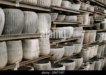 A variety of empty decorative ceramic flower pots in different sizes and shapes for sale on the shelves at the garden center Stock Photo