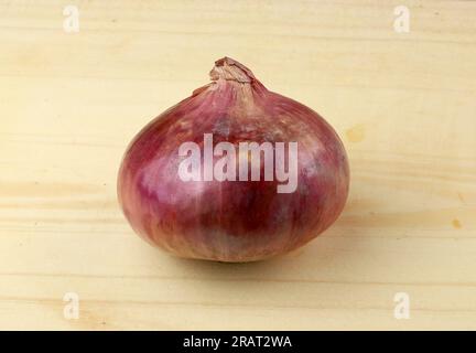 Red whole onion isolated on wooden board Stock Photo