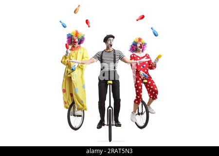 Mime and clown juggling and riding unicycles on a pedestrian crossing ...