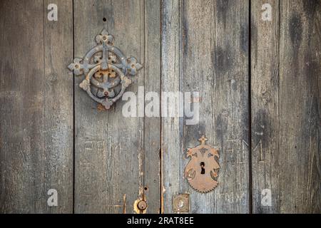 Detail of old dark wooden door with metal knocker and lock Stock Photo