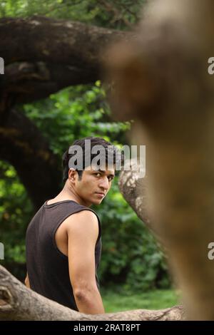 Young teen boy posing in the park in greens and serene atmosphere. Martial arts expert in city park. Stock Photo