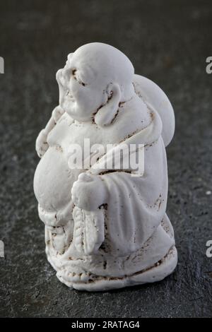 A carved miniature of the god, Buddha, walking and laughing Stock Photo