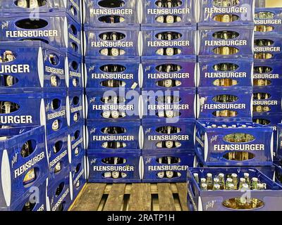 Viersen, Germany - July 4. 2023: Closeup of many blue stacked Flensburger beer bottle crates on euro palette in storage Stock Photo