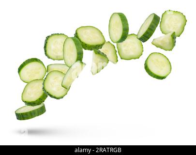 Slices of green cucumbers on a white isolated background. Slices of green cucumbers scatter in different directions. The concept of a delicious Stock Photo