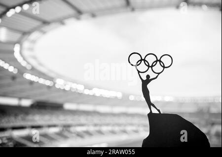 PARIS, FRANCE, JULY 7, 2023: Symbolic Power: Statue of Athletic Woman Raises Olympic Circle at Modern Olympic Stadium. Sport Photo for Paris 2024 Summ Stock Photo