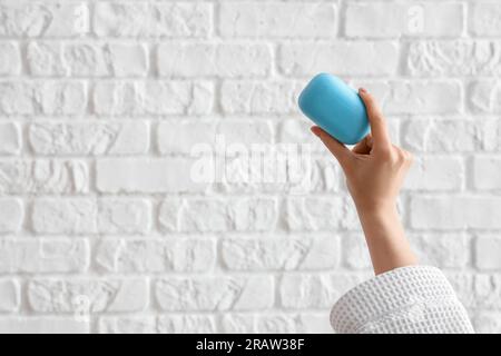 Hand with soap on white brick background Stock Photo