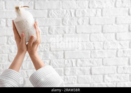 Hands with liquid soap on white brick background Stock Photo