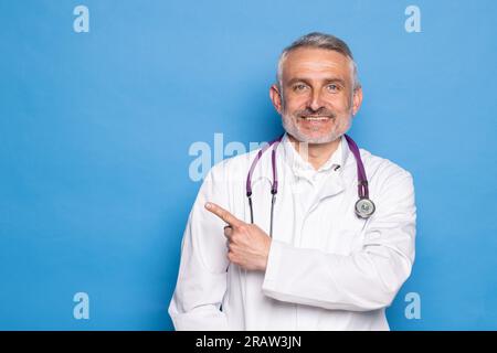 handsome doctor man wearing coat and stethoscope over isolated blue background Stock Photo